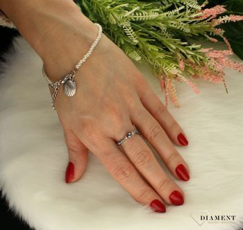 Bransoletka damska z koralikami w perłowym kolorze muszelka 000-WON-IBPW113.Wyjątkowa damska bransoletka, która składa się z koralików w perłowym mieniącym się kolorze i zawieszki srebrnej muszelki. Zapięcie bransoletki to w.jpg