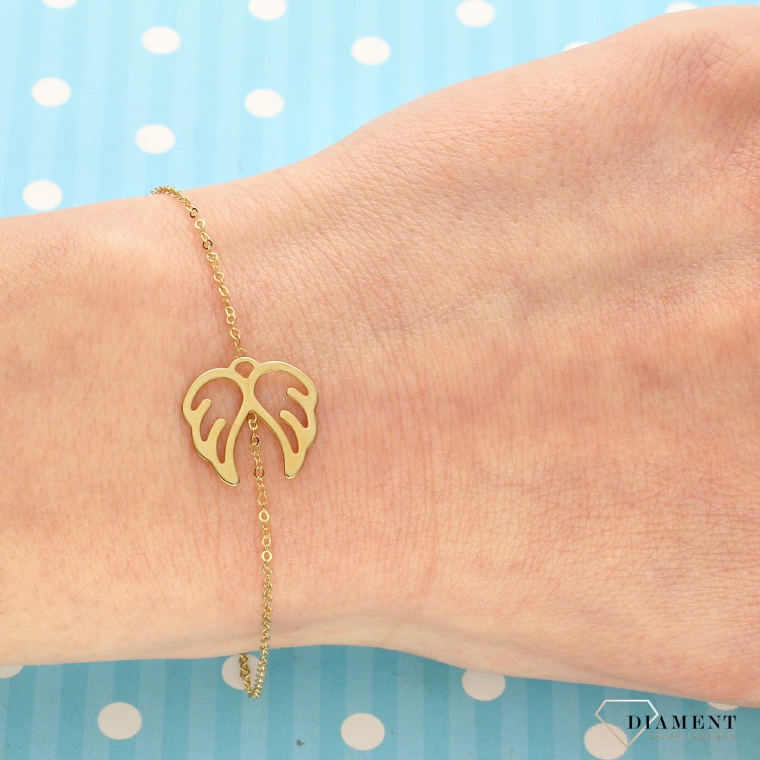 Złota bransoletka typu celebrytka z ozdobnym elementem w postaci skrzydeł. Bransoletka wykonana z 14-karatowego żółtego złota. Prezent dla mamy.  (1).jpg