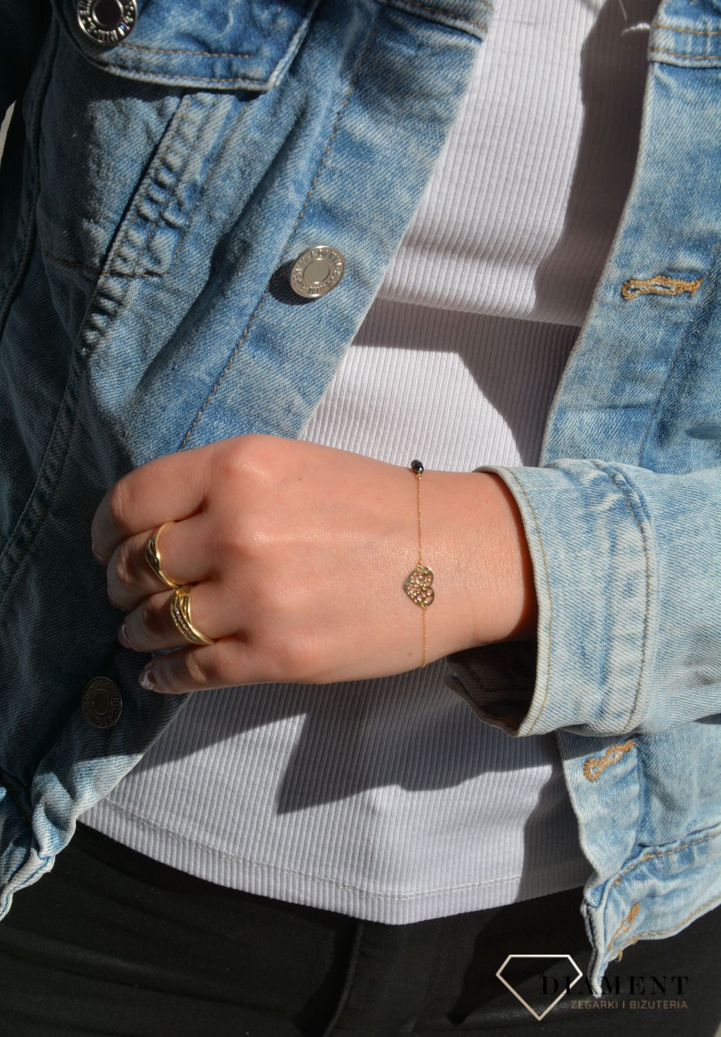 Złota bransoletka celebrytka na delikatnym łańcuszku ozdobiona została zawieszką w kształcie ażurkowego serca oraz trzech czarnych koralików. Zapraszamy!  (1).jpg