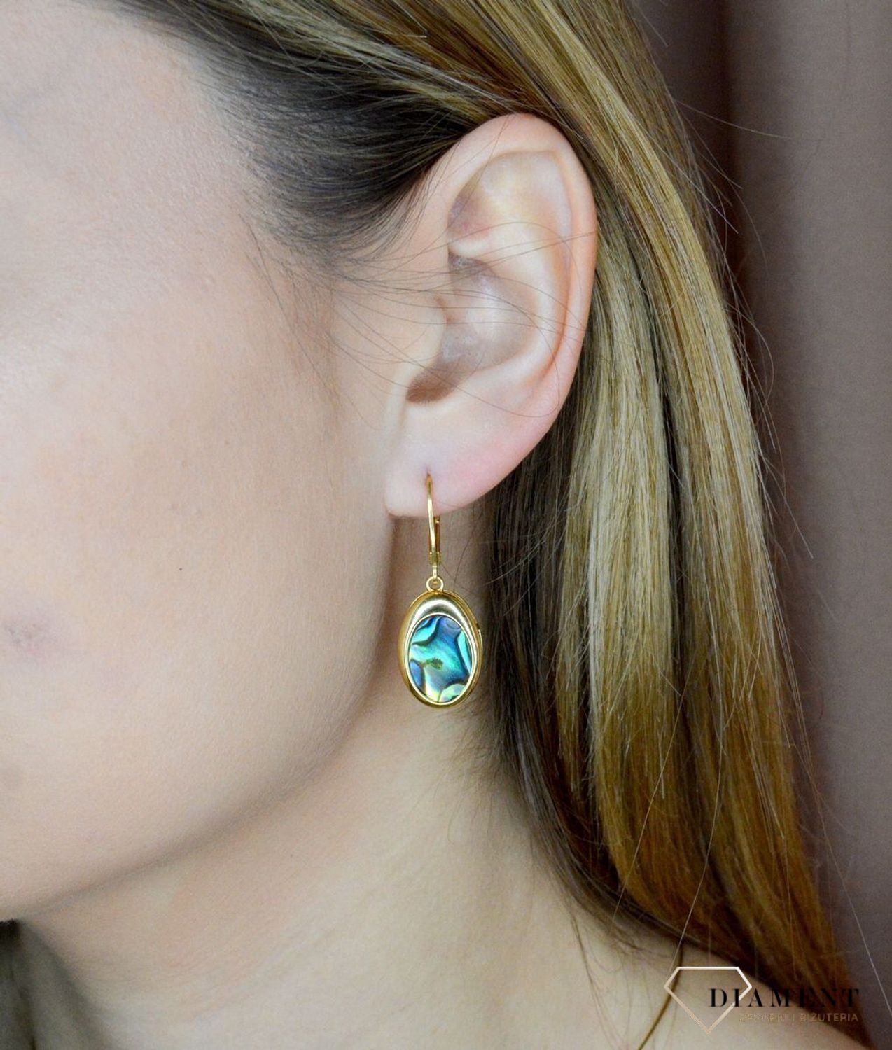 Srebrne kolczyki wiszące pokryte złotem z muszlą naturalną 0712858290. Kolczyki o owalnym kształcie z muszlą naturalną to doskonała propozycja dla osób szukających modnych, minimalistycznych dodatków. Kolczyki z wygodnym zapięciem .jpg