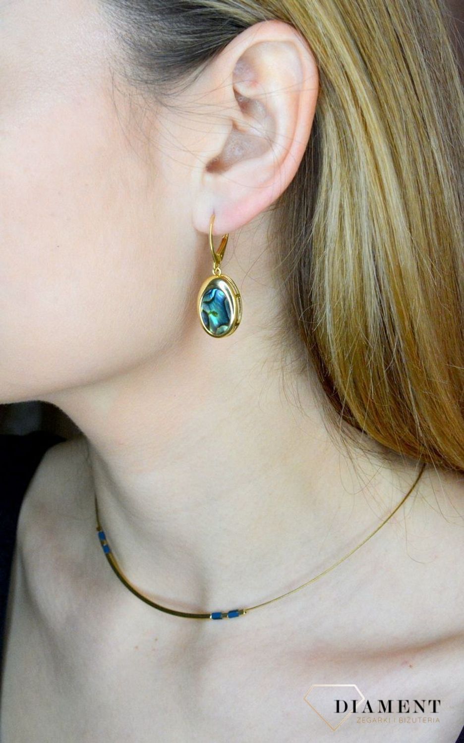 Srebrne kolczyki wiszące pokryte złotem z muszlą naturalną 0712858290. Kolczyki o owalnym kształcie z muszlą naturalną to doskonała propozycja dla osób szukających modnych, minimalistycznych dodatków. Kolczyki z wygodnym zapięciem .jpg