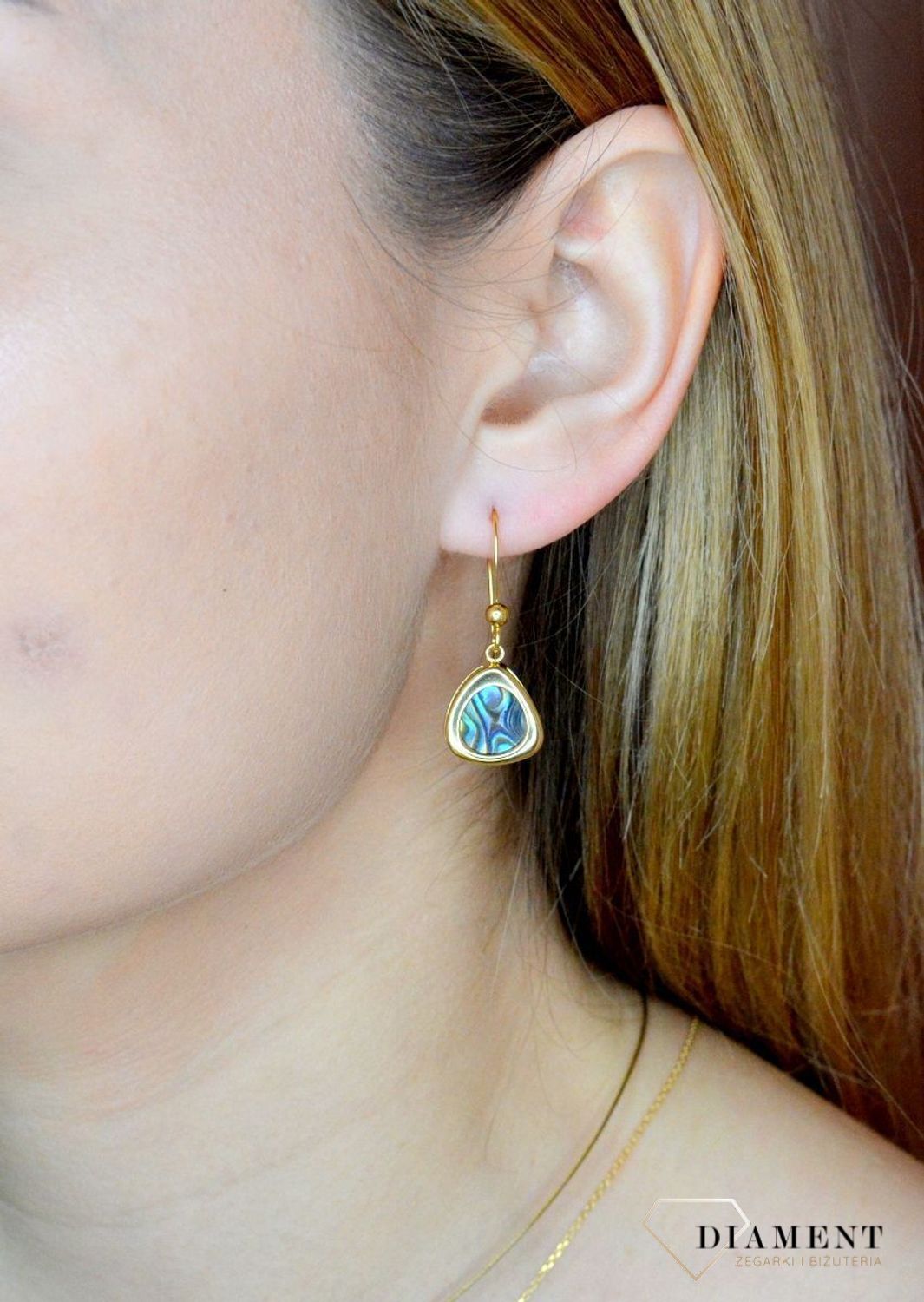 Srebrne kolczyki wiszące pokryte złotem z muszlą naturalną 0714858190.  Kolczyki o nieregularnym kształcie z muszlą naturalną to doskonała propozycja dla osób szukających modnych, minimalistycznych dodatków. Kolczyki z wygodnym zapię.jpg