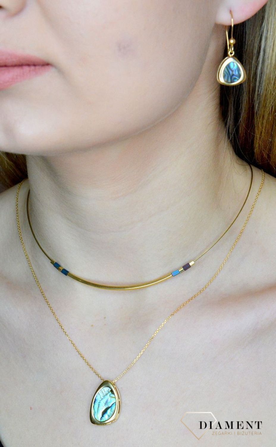 Srebrne kolczyki wiszące pokryte złotem z muszlą naturalną 0714858190.  Kolczyki o nieregularnym kształcie z muszlą naturalną to doskonała propozycja dla osób szukających modnych, minimalistycznych dodatków. Kolczyki z wygodnym zapię.jpg