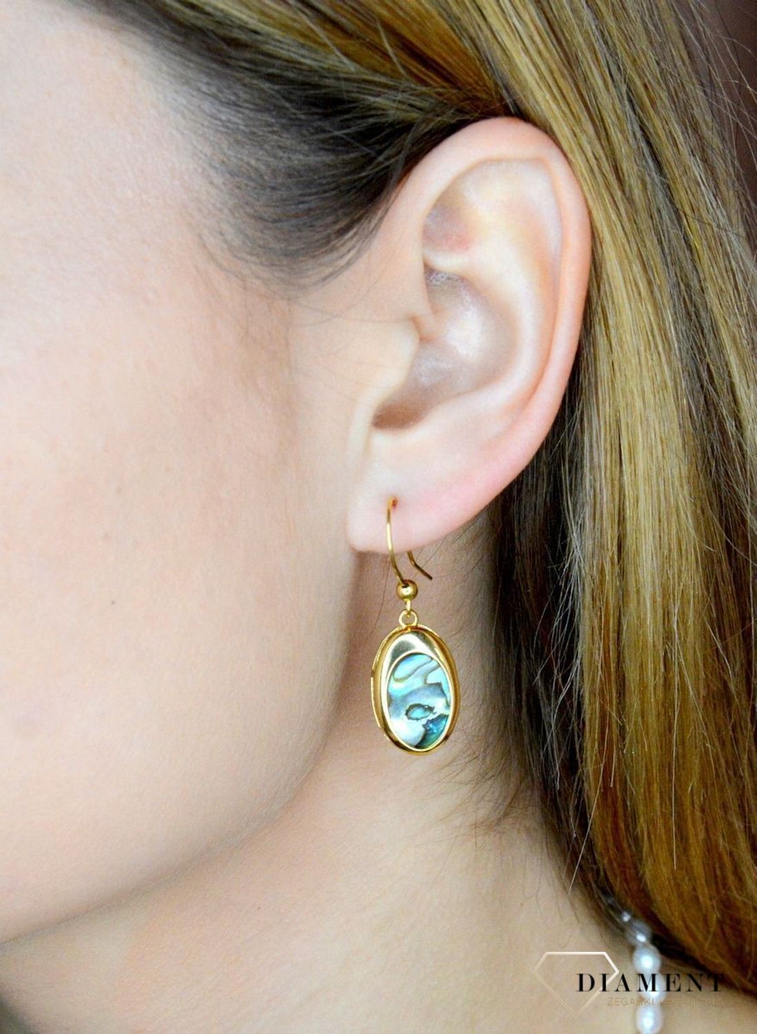 Srebrne kolczyki wiszące pokryte złotem z muszlą naturalną 0714858290. Kolczyki o owalnym kształcie z muszlą naturalną to doskonała propozycja dla osób szukających modnych, minimalistycznych dodatków. Kolczyki z wygodnym zapięciem na.jpg