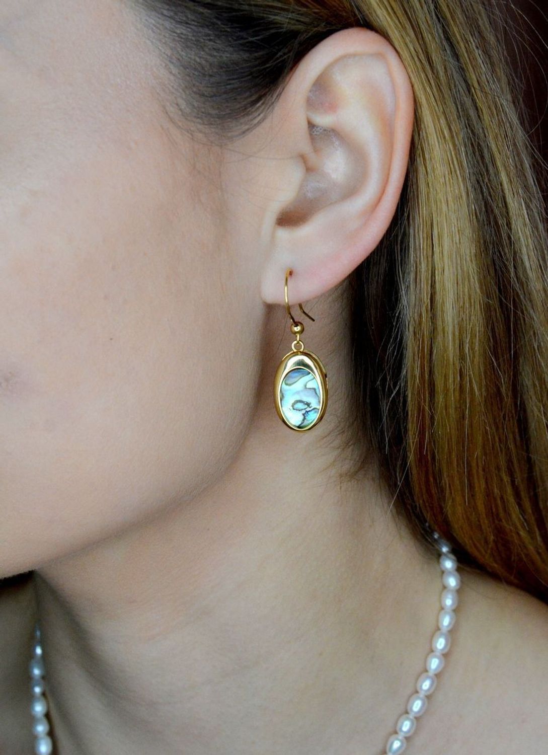 Srebrne kolczyki wiszące pokryte złotem z muszlą naturalną 0714858290. Kolczyki o owalnym kształcie z muszlą naturalną to doskonała propozycja dla osób szukających modnych, minimalistycznych dodatków. Kolczyki z wygodnym zapięciem na.jpg