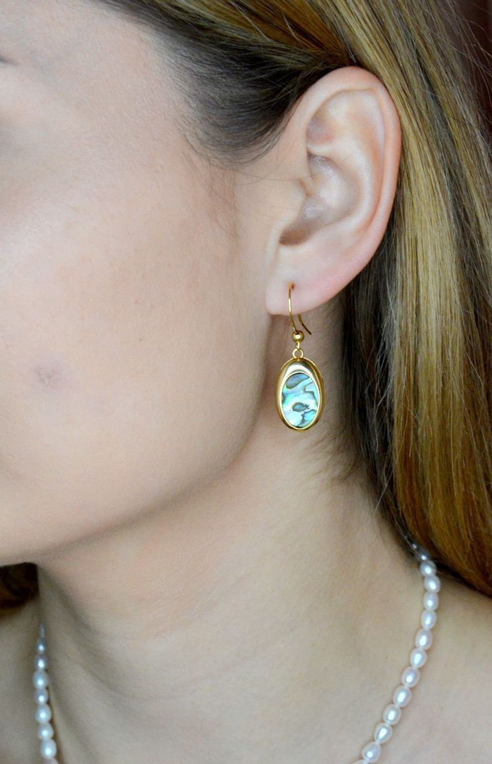 Srebrne kolczyki wiszące pokryte złotem z muszlą naturalną 0714858290. Kolczyki o owalnym kształcie z muszlą naturalną to doskonała propozycja dla osób szukających modnych, minimalistycznych dodatków. Kolczyki z wygodnym zapięciem na.jpg