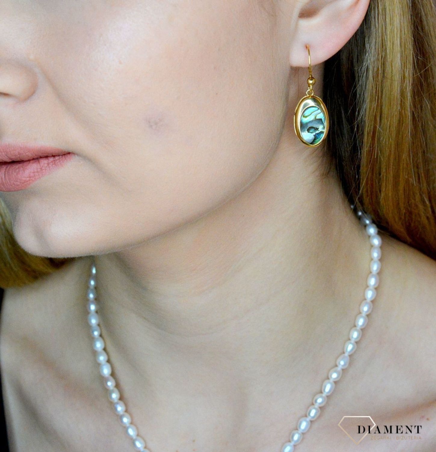 Srebrne kolczyki wiszące pokryte złotem z muszlą naturalną 0714858290. Kolczyki o owalnym kształcie z muszlą naturalną to doskonała propozycja dla osób szukających modnych, minimalistycznych dodatków. Kolczyki z wygodnym zapięciem na.jpg