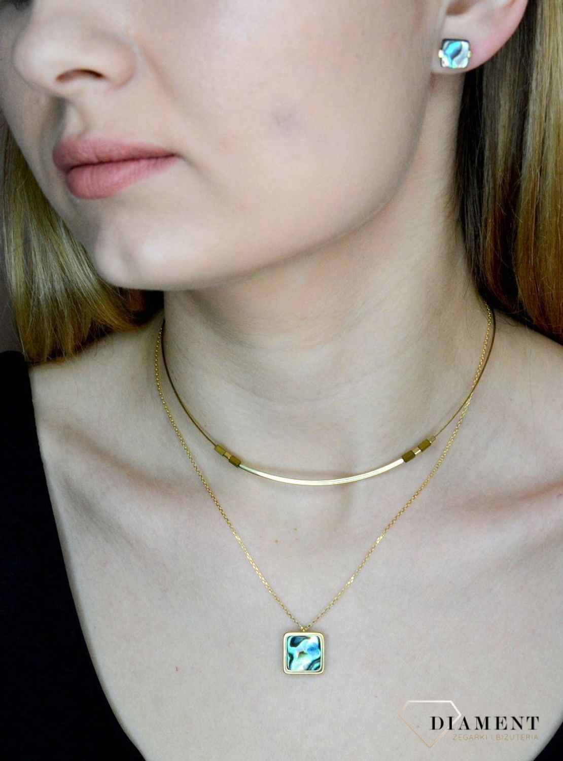 Srebrne kolczyki pokryte złotem z muszlą naturalną 0718160400. Drobne kolczyki w kształcie kwadratu z muszlą naturalną to doskonała propozycja dla osób szukających modnych, minimalistycznych dodatków. Kolczyki z wygodnym zapięciem na.jpg