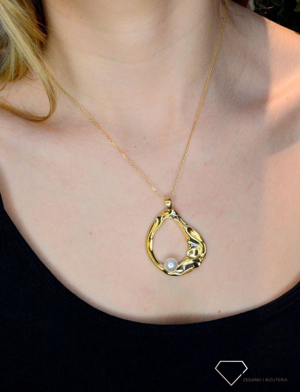 Srebrna zawieszka pozłacana z perłą Swarovskiego 0768153500. Zawieszka została ukształtowana na modny wzór markizy, ozdobiony dodatkowo perłą Swarovskiego. Wielkość  zawieszki 4,5 x 5,5 cm.jpg