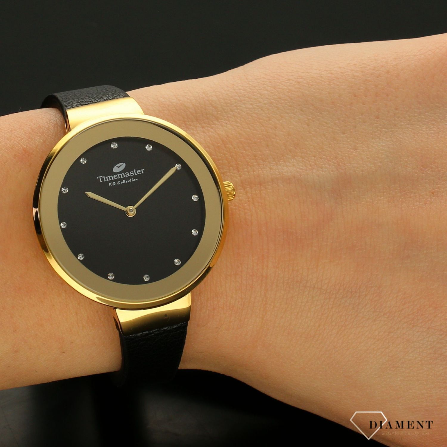 Zegarek damski w kolorze złotym na czarnym paski TIMEMASTER 206-8. Zegarek damski z pozłacaną okrągłą kopertą w kolorze złotym. Zegarek z czarnym skórzanym paskiem. Tarcza w kolorze czarnym z błyszczącymi cyrkoniami. Świetny p.jpg
