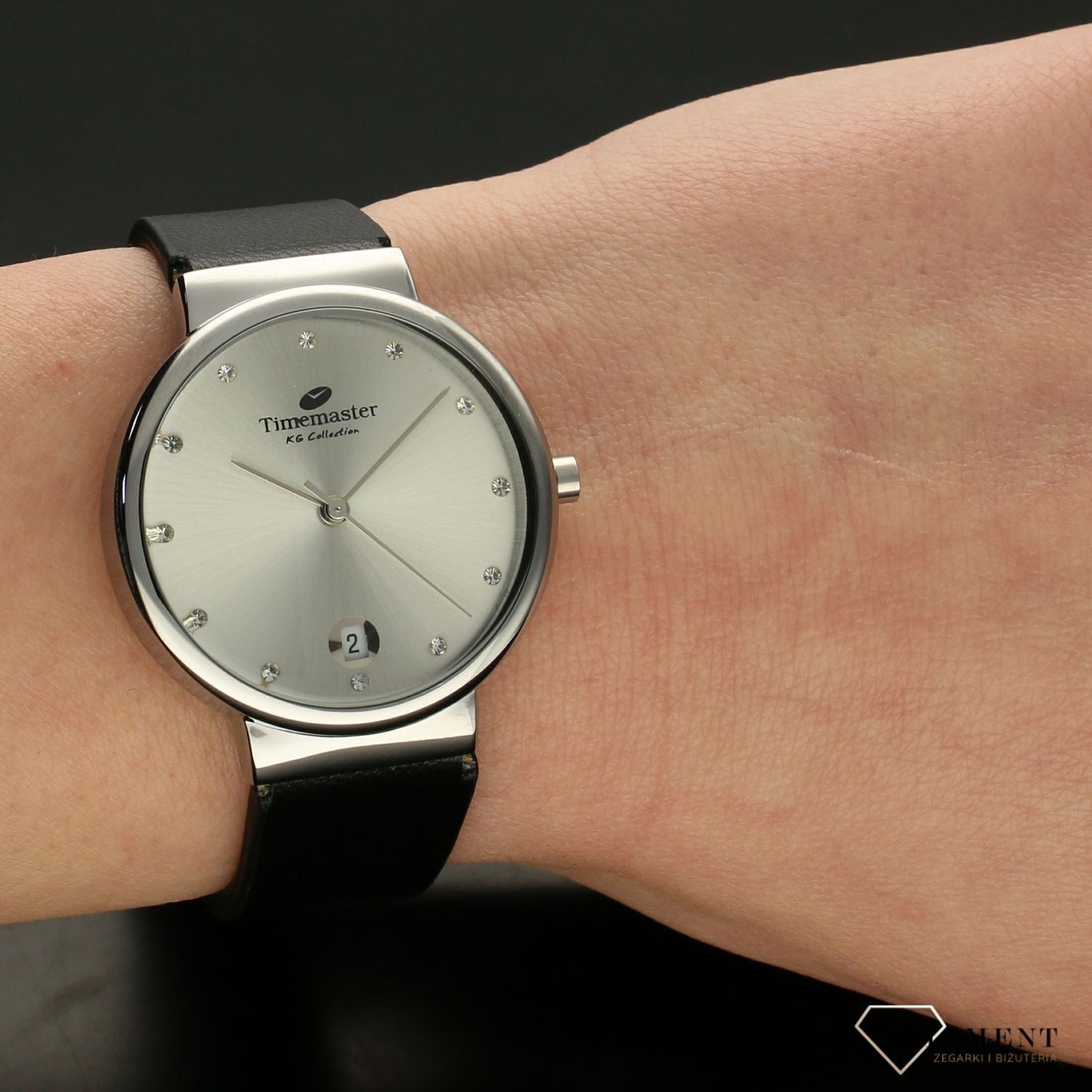 Zegarek damski TIMEMASTER 208-1S czarny pasek. Zegarek damski zachowany w klasycznej formie. Tarcza zegarka w kolorze srebrnym z wyraźnym datownikiem w formie popularnego okienka. Indeksy w formie cyrkonii.  (2).jpg