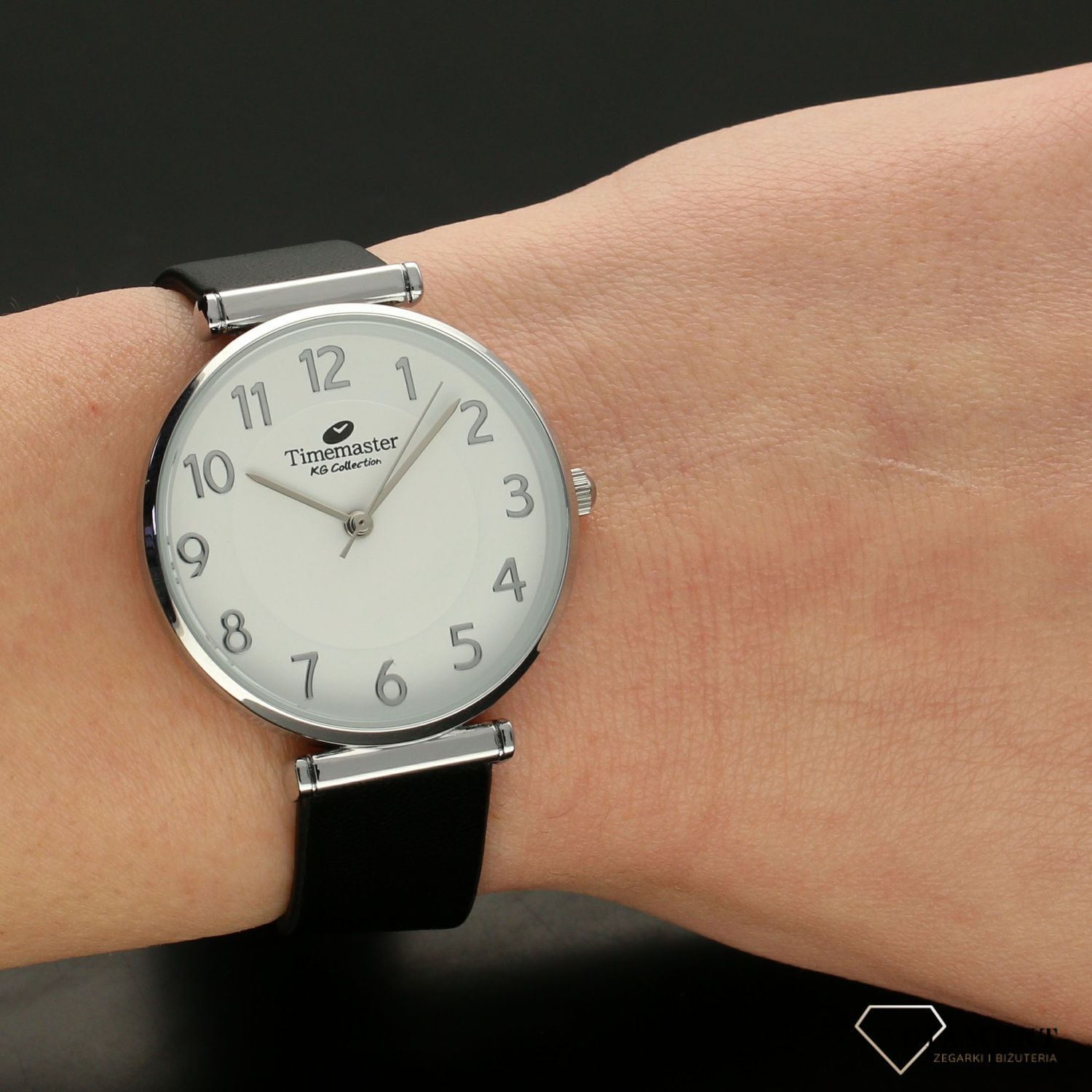 Zegarek damski TIMEMASTER klasyczny 208-38. Zegarek damski zachowany w klasycznej formie. Zegarek damski. Zegarek z białą tarczą z wyraźnymi srebrnymi cyframi arabskimi. Pasek skórzany w kolorze czarnym.  (2).jpg