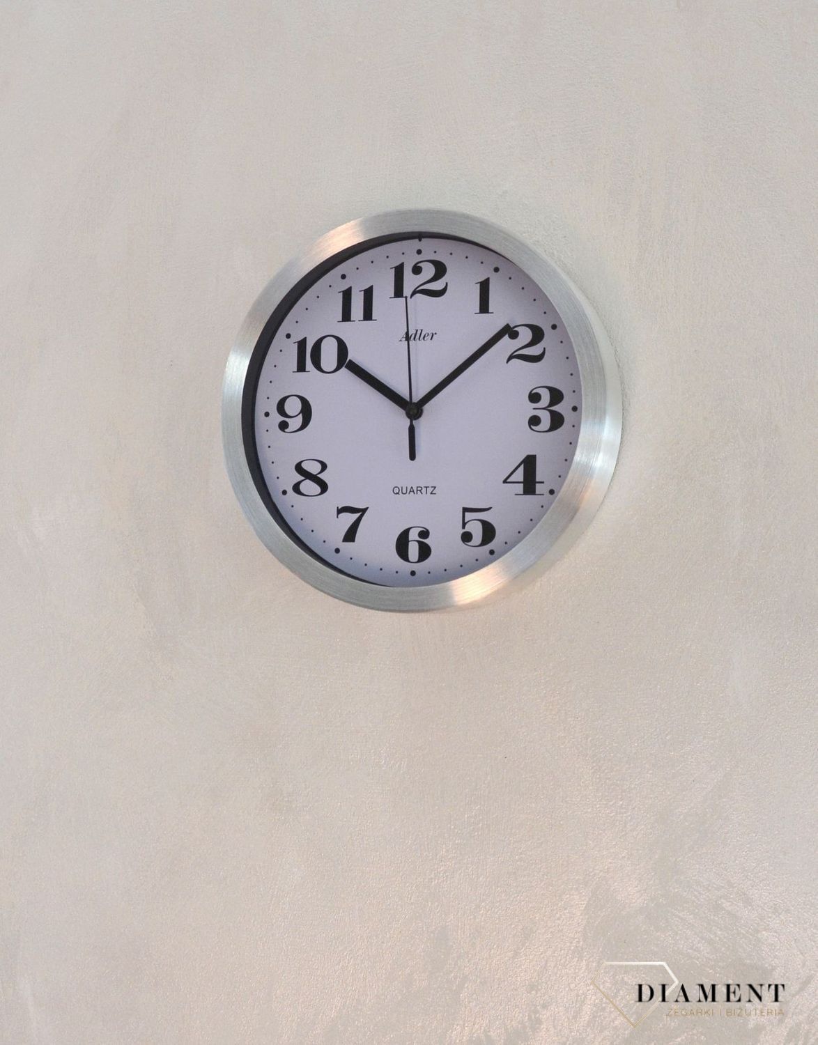 Zegar ścienny okrągły ADLER srebrny 30087. Zegar ścienny aluminiowy w klasycznym wydaniu. Tarcza zegara w kolorze białym z czarnym cyframi arabskimi i wskazówkami. Zegar ścienny zasilany za pomocą baterii. Zegar na ścianę.  (1).JPG