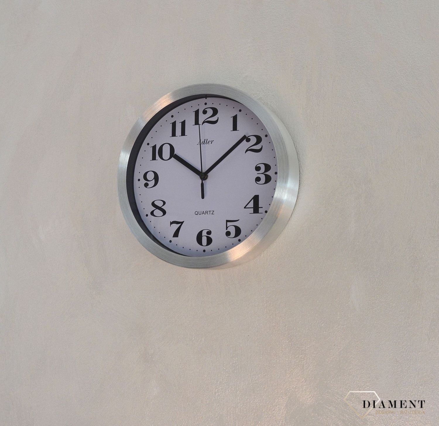 Zegar ścienny okrągły ADLER srebrny 30087. Zegar ścienny aluminiowy w klasycznym wydaniu. Tarcza zegara w kolorze białym z czarnym cyframi arabskimi i wskazówkami. Zegar ścienny zasilany za pomocą baterii. Zegar na ścianę.  (1).JPG