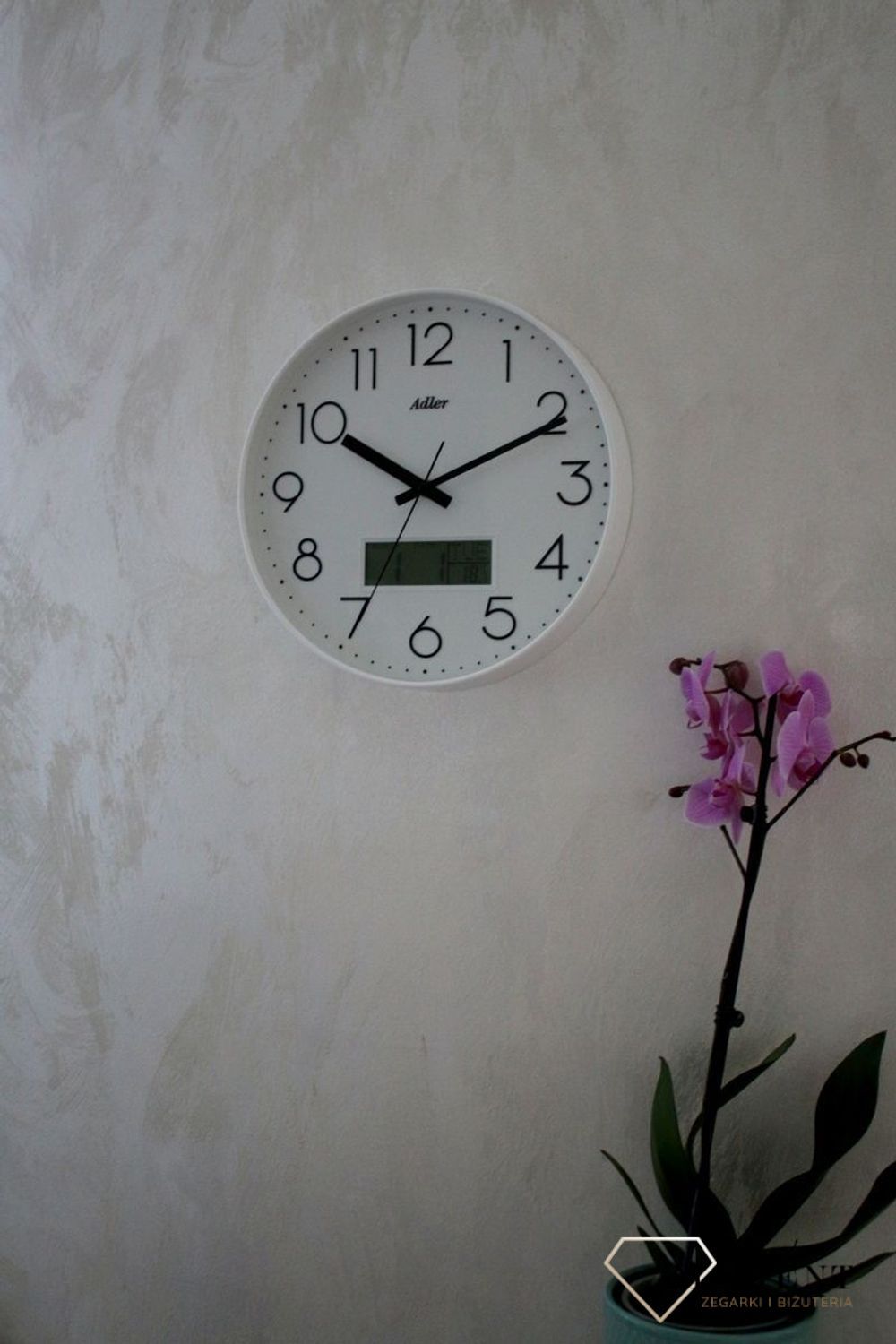 Zegar ścienny okrągły Adler Biały z datownikiem i termometrem 30173. Zegar ścienny Adler okrągły wyposażony jest w kwarcowy mechanizm, zasilany za pomocą baterii (1).JPG