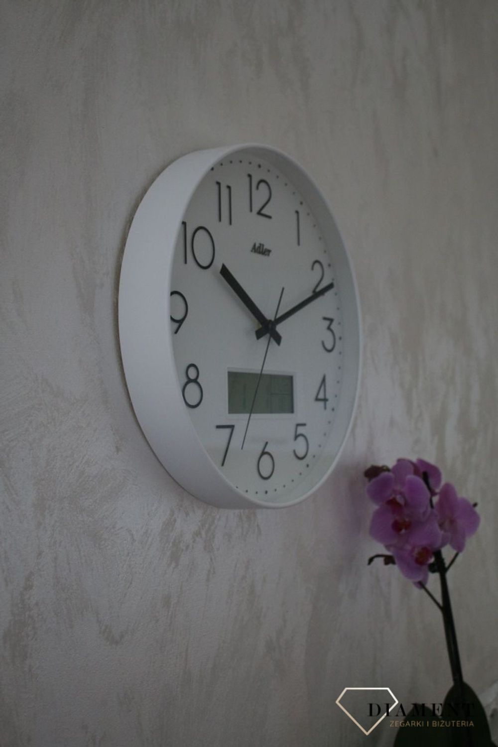 Zegar ścienny okrągły Adler Biały z datownikiem i termometrem 30173. Zegar ścienny Adler okrągły wyposażony jest w kwarcowy mechanizm, zasilany za pomocą baterii (1).JPG