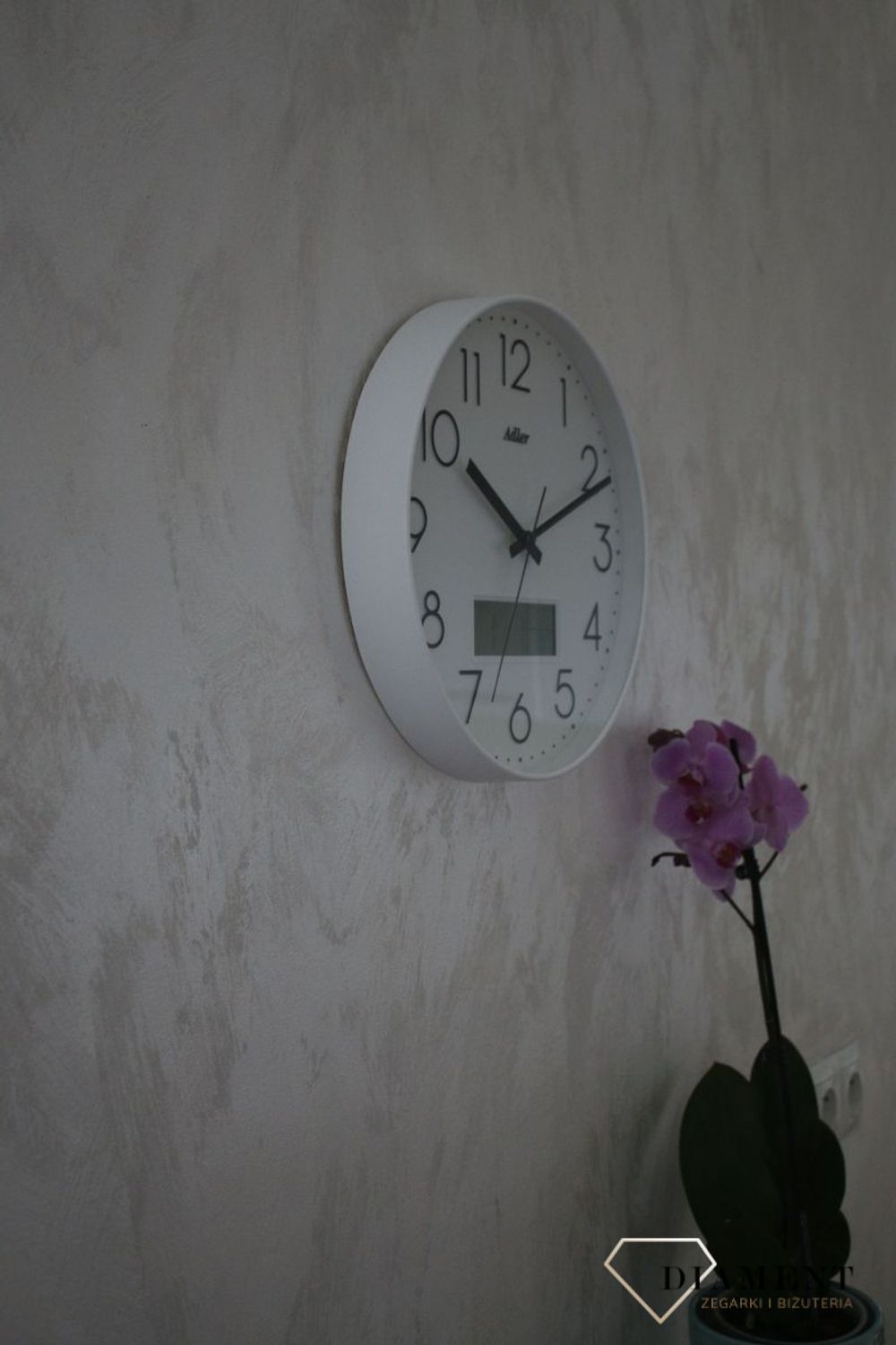Zegar ścienny okrągły Adler Biały z datownikiem i termometrem 30173. Zegar ścienny Adler okrągły wyposażony jest w kwarcowy mechanizm, zasilany za pomocą baterii (1).JPG