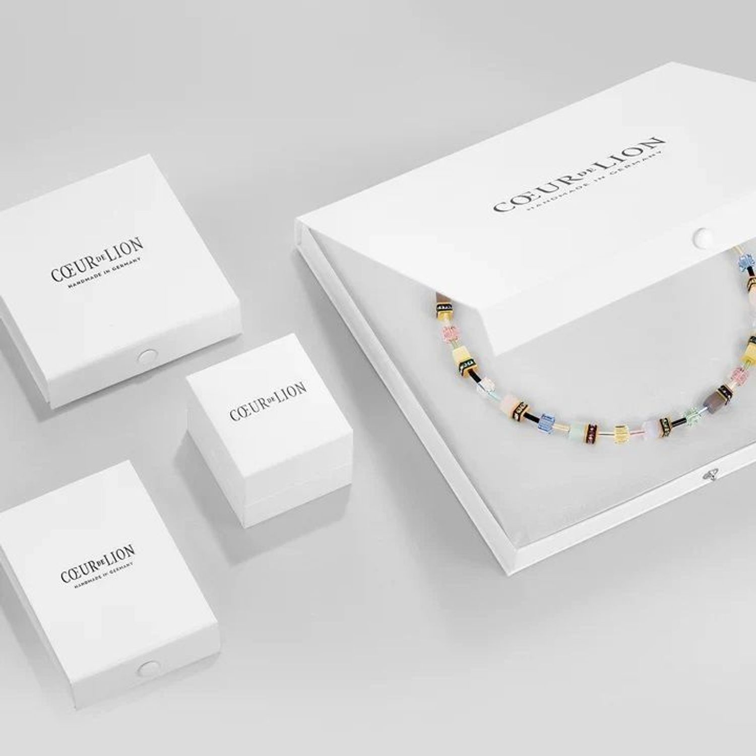 Coeur De Lion GeoCUBE® Iconic Monochrome Earrings w kolorze brzoskwiniowym. Eleganckie kolczyki 2,9 cm ze stali nierdzewnej, kryształów i oka tygrysa.22.jpg