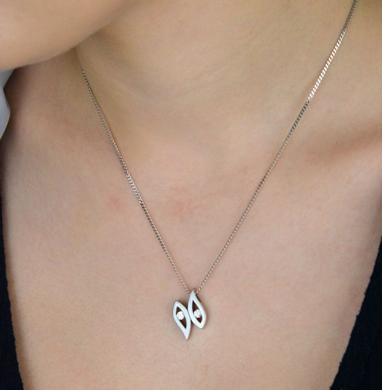 Zawieszka damska geometryczna AP04-2062 wykonana ze srebra próby 925, zdobiona dwiema cyrkoniami. Nowoczesna forma, waga 3,11 g, wymiary 1,3 × 1,5 cm. Stylowy dodatek i pomysł na prezent.1.jpg