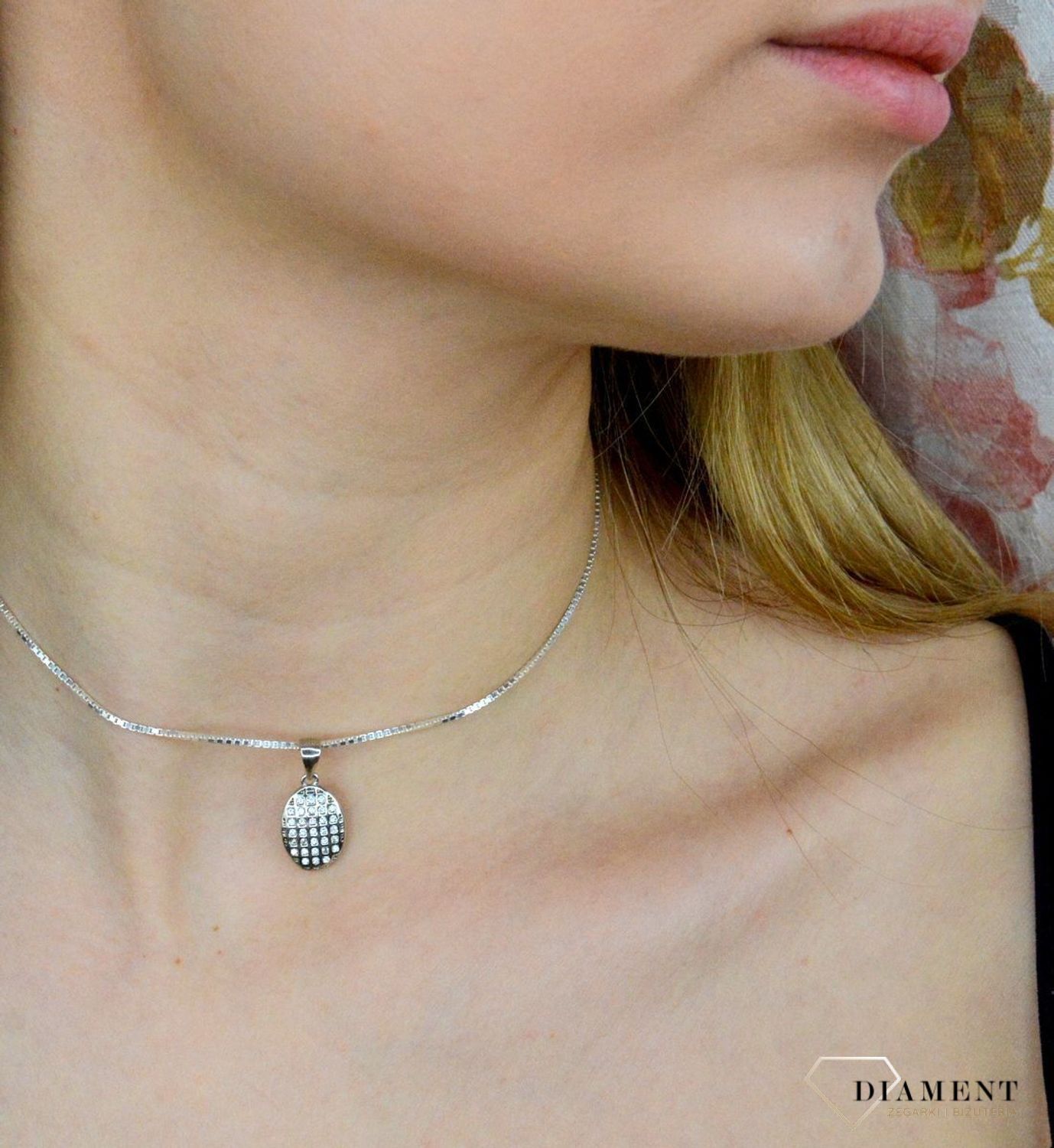 Srebrna zawieszka o owalnym kształcie wysadzona cyrkoniami AZZ000000-275. Drobna zawieszka wysadzana cyrkoniami stanowi piękną ozdobę dekoltu. Subtelna, a jednocześnie elegancka zawieszka sprawdzi się idealnie na prezen.jpg