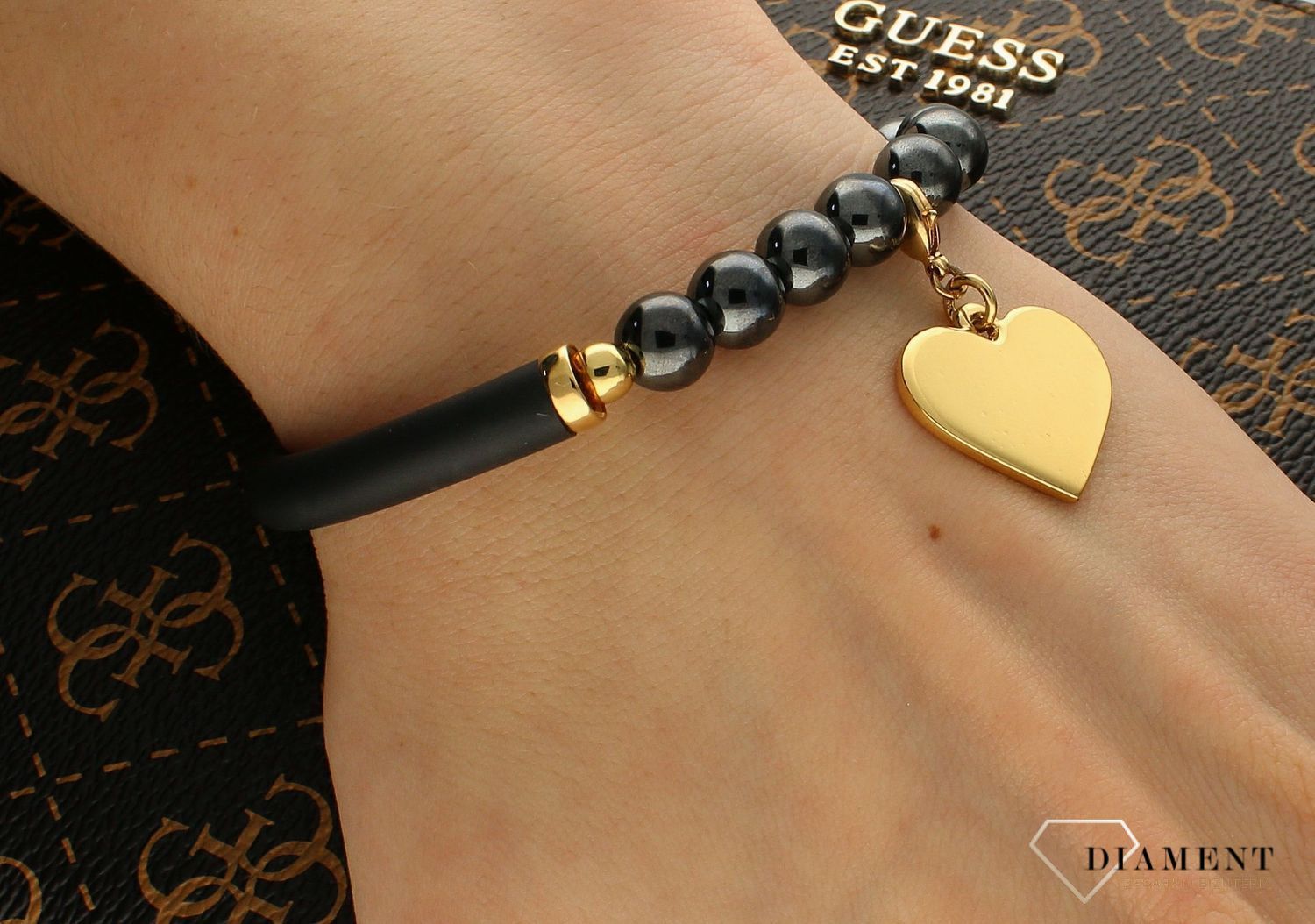 Bransoletka Karpiński 'Złote serce' B12812Au. Bransoletka Karpiński 'Złote serce'. Wyjątkowa damska bransoletka, która łączy w sobie hematyty, kauczuk i pozłacane 24K złotem serce. Zawieszka wykonana z wysokiej jakoś.jpg