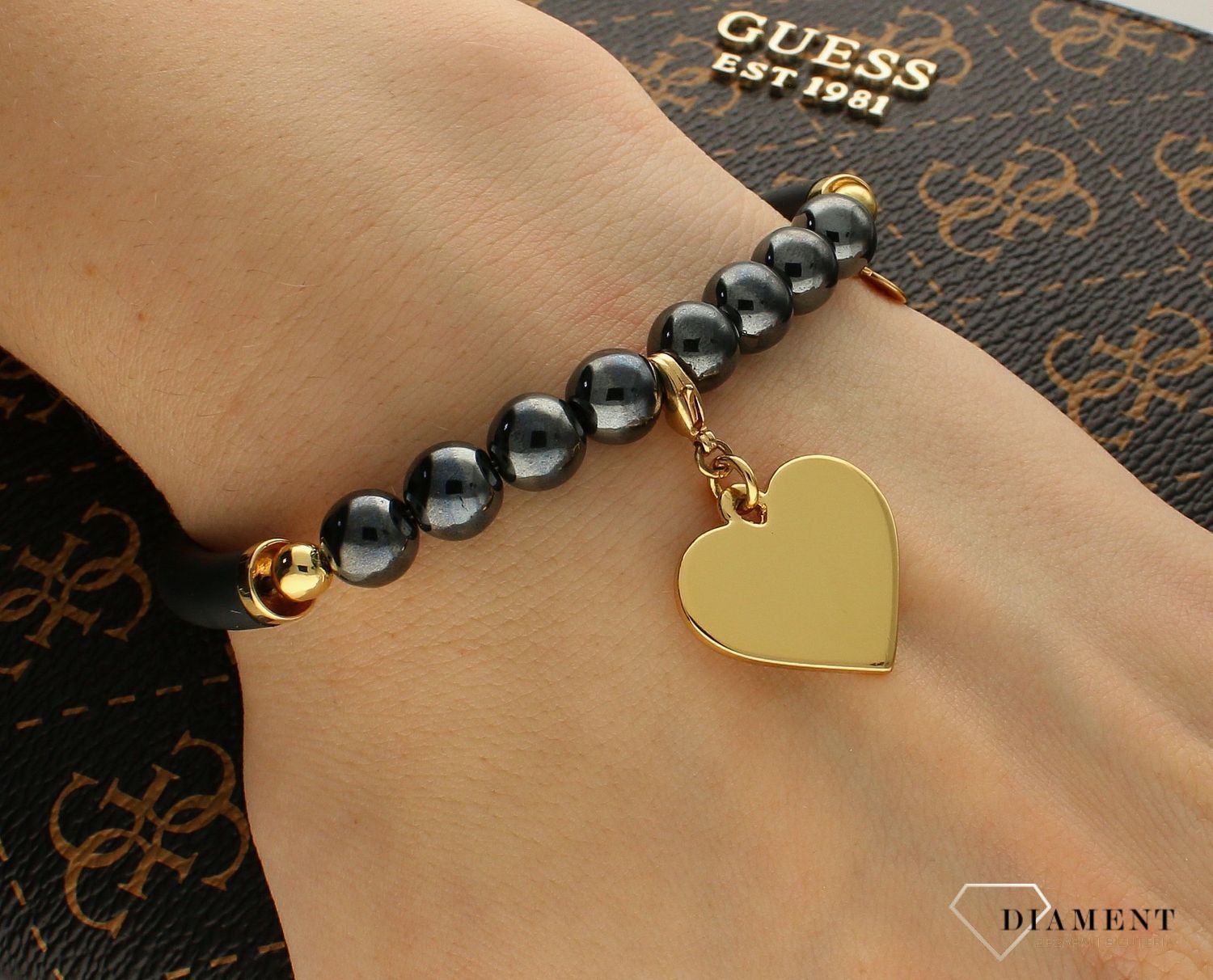 Bransoletka Karpiński 'Złote serce' B12812Au. Bransoletka Karpiński 'Złote serce'. Wyjątkowa damska bransoletka, która łączy w sobie hematyty, kauczuk i pozłacane 24K złotem serce. Zawieszka wykonana z wysokiej jakoś.jpg