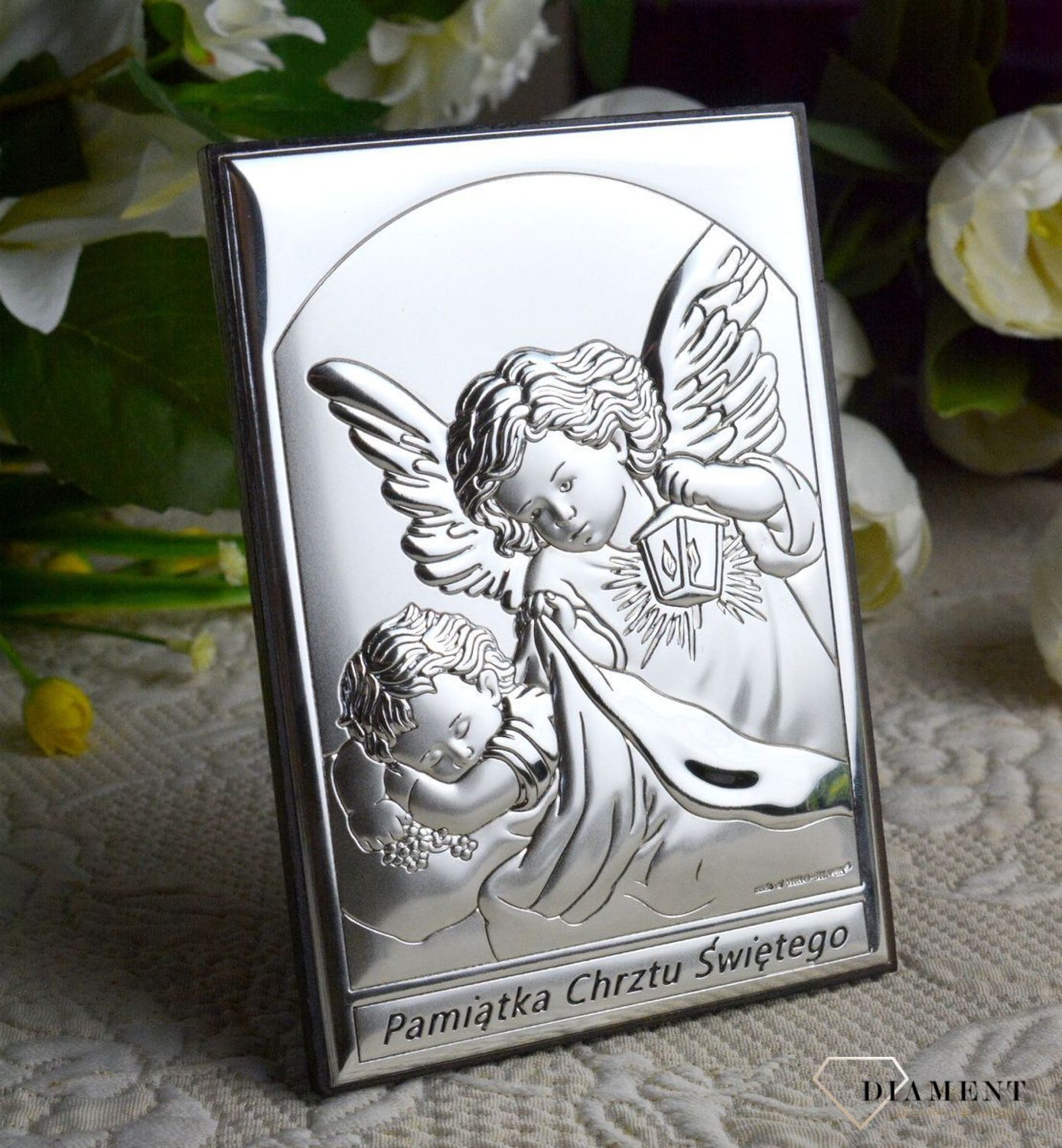Obrazek srebrny przedstawiający Aniołki to idealny upominek z okazji Chrztu Świętego, który powinien zagościć w każdym dziecięcym pokoju wnosząc radość.  Wykonany z wysokiej jakości drewna oraz metalu pokrytego srebrem.jpg