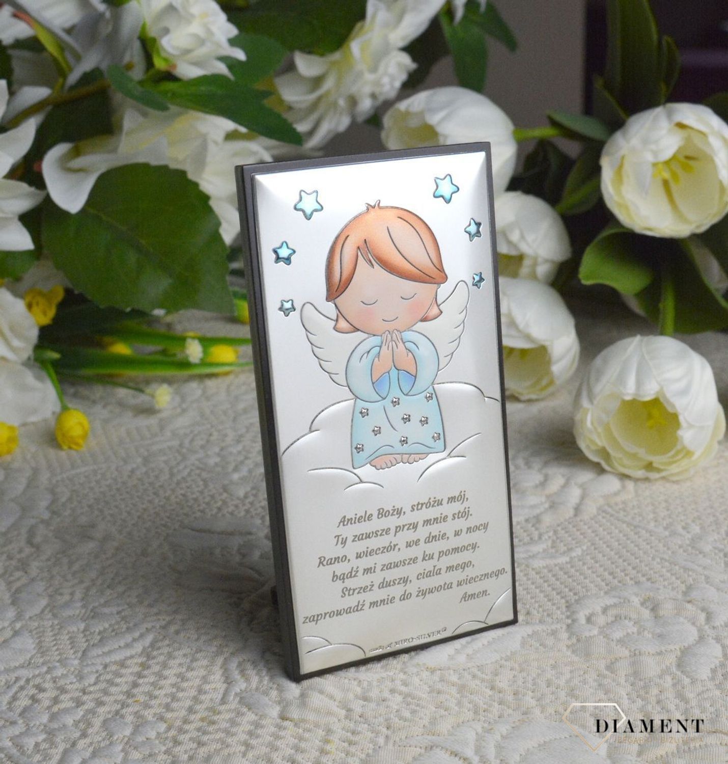 Obrazek srebrny z Aniołem Stróżem w niebieskim odcieniu to piękna ozdoba dziecięcego pokoju. Wykonany z wysokiej jakości drewna oraz metalu pokrytego srebrem i lakierem zabezpieczającym, dzięki któremu produkt zachowa swój b.webp