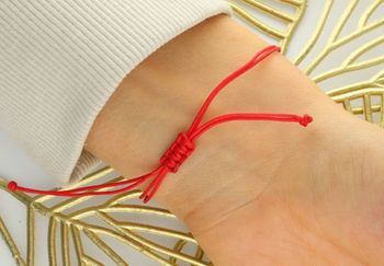 Subtelna bransoletka damska ze złota próby 585 na czerwonym sznureczku z literką „M”. Ściągane zapięcie, regulowana długość, idealna na prezent lub jako osobisty talizman3.jpg