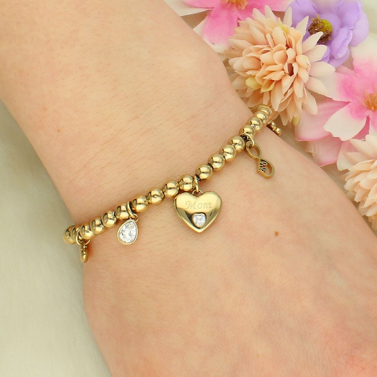 Bransoletka damska stalowa BROSWAY '' Chakra Rodzina'' BHKB166 💎 Bransoletka wykonana ze stali w kolorze złotym 💎 Bransoletka z zawieszkami w kształcie serca z grawerem Mama, czterolistną koniczyną, nieskończonością z na.jpg