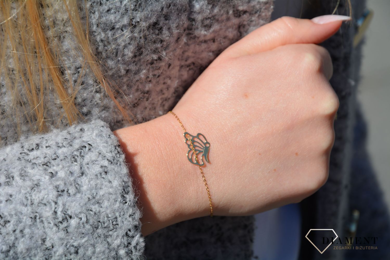 Złota bransoletka typu celebrytka z ozdobnym elementem w postaci motyla. Bransoletka składa się z drobnego, ażurkowego łańcuszka. Bransoletka z przedłużką.  (2).jpg