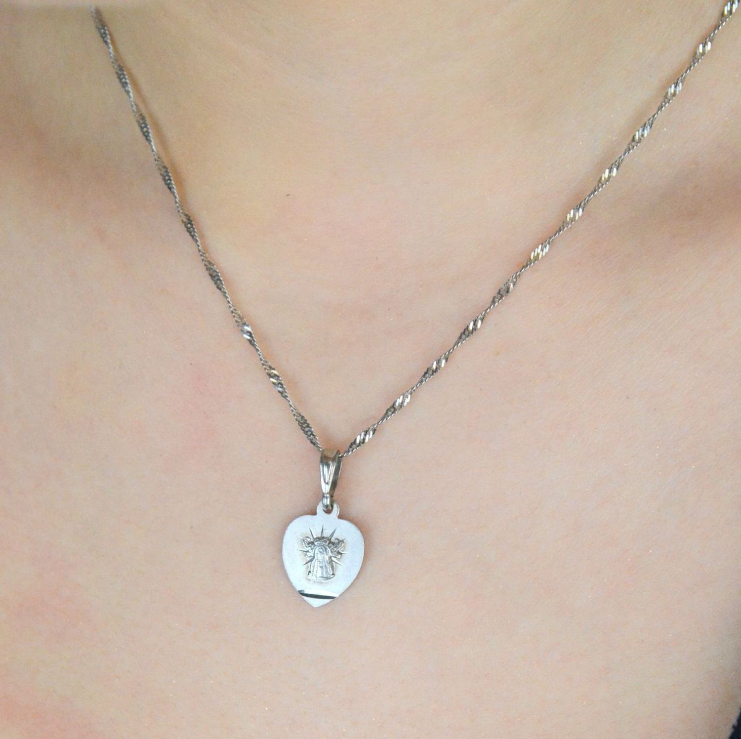 Elegancki srebrny medalik z wizerunkiem Matki Boskiej Licheńskiej w kształcie serca. Wykonany ze srebra próby 925, waga 1,5 g, idealny jako prezent duchowy. Sprawdź!1.jpg