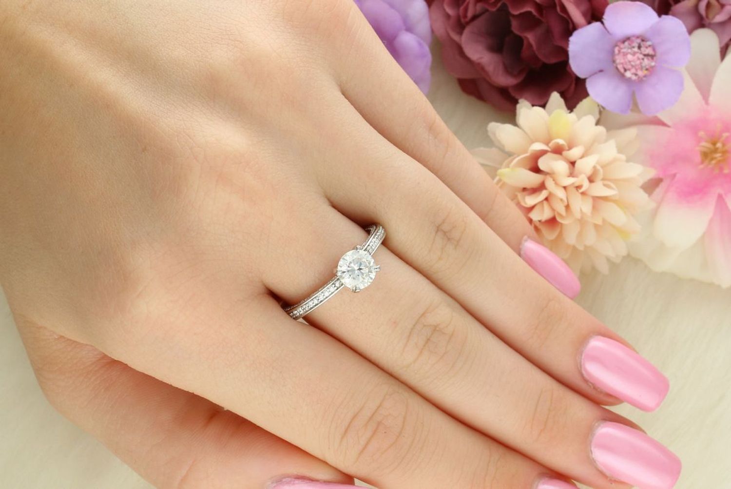 Elegancki srebrny pierścionek z centralnym moissanitem w czterech łapkach i dodatkowymi kamieniami po bokach. Ponadczasowy design idealny na prezent i wyjątkowe okazje (1).jpg