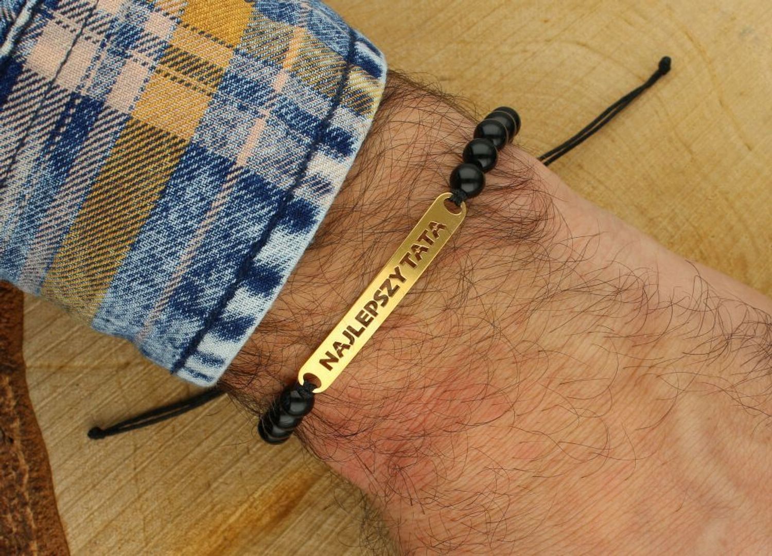 Pozłacana bransoletka „Najlepszy Tata” ze srebra 925 na czarnym sznurku z onyksami. Regulowana długość, elegancka blaszka 5,9 × 41,7 mm. Idealny prezent dla taty na każdą okazję.1.jpg