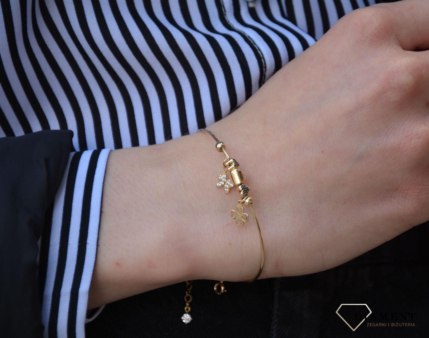 Złota, sztywna bransoletka z elementami ozdobnymi w postaci motylka i koniczynki. Bransoletka wykonana z wysokiej jakości złota próby 585. Zapraszamy!  (1).jpg