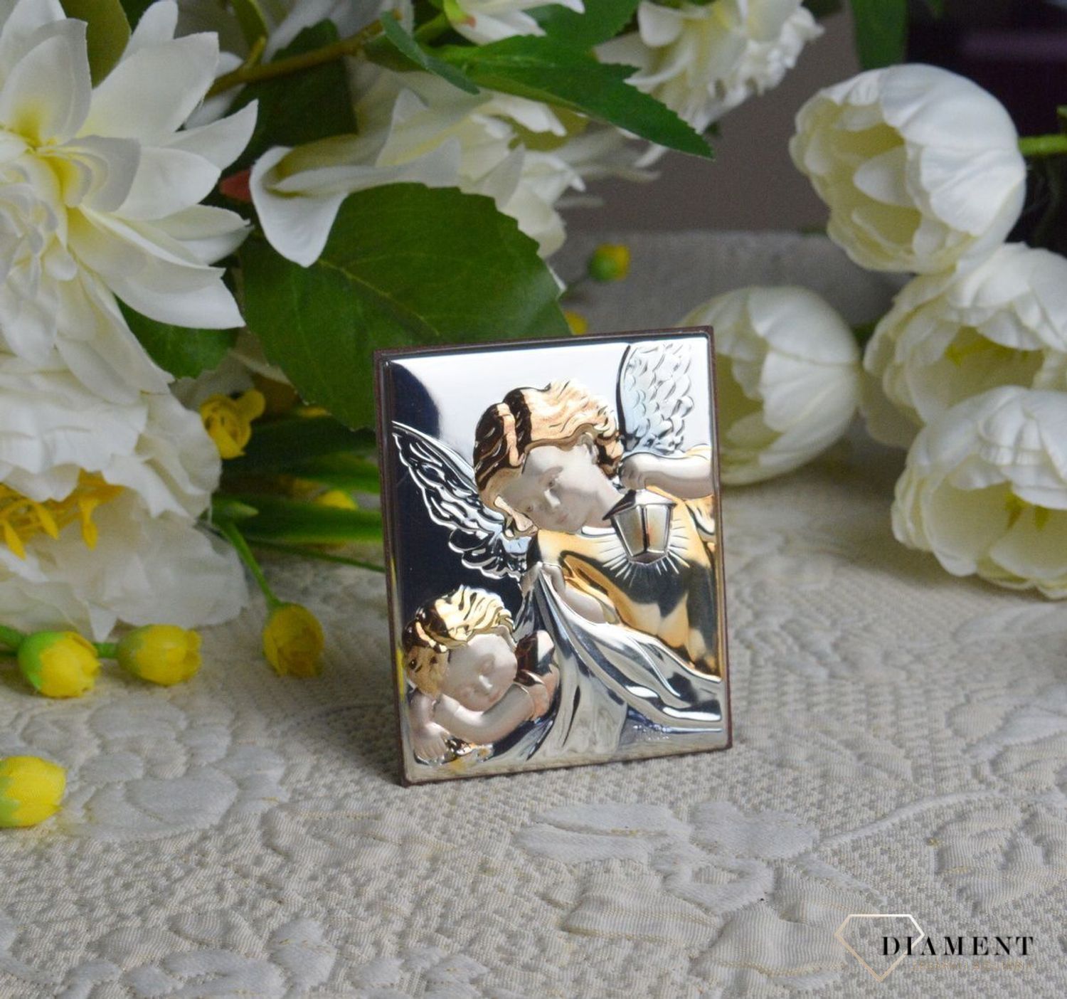 Obrazek srebrny z Aniołem Stróżem to piękna ozdoba dziecięcego pokoju. Pamiątka jest symbolicznym przedstawieniem opieki roztoczonej nad malcem przez Bożą.jpg