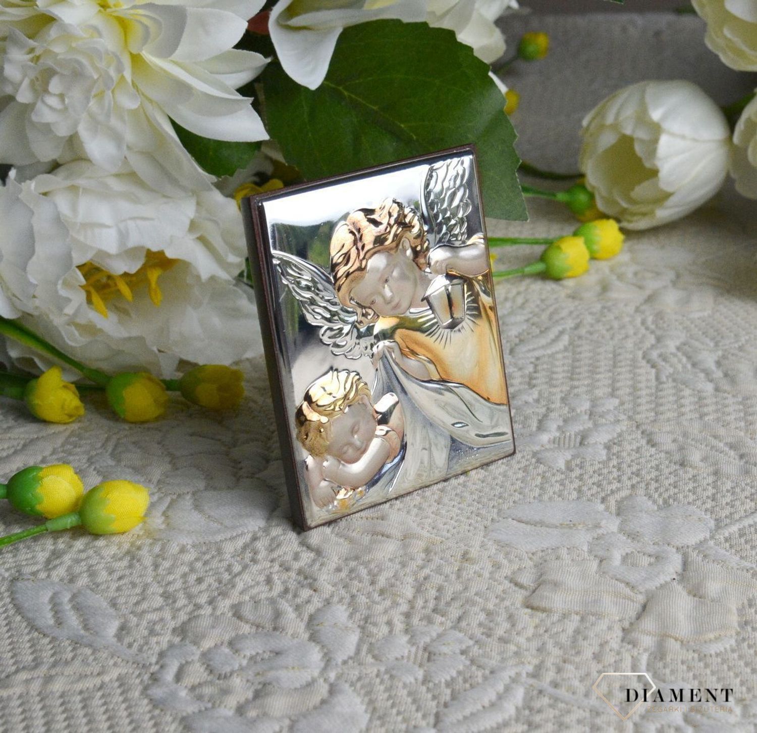 Obrazek srebrny z Aniołem Stróżem to piękna ozdoba dziecięcego pokoju. Pamiątka jest symbolicznym przedstawieniem opieki roztoczonej nad malcem przez Bożą.jpg