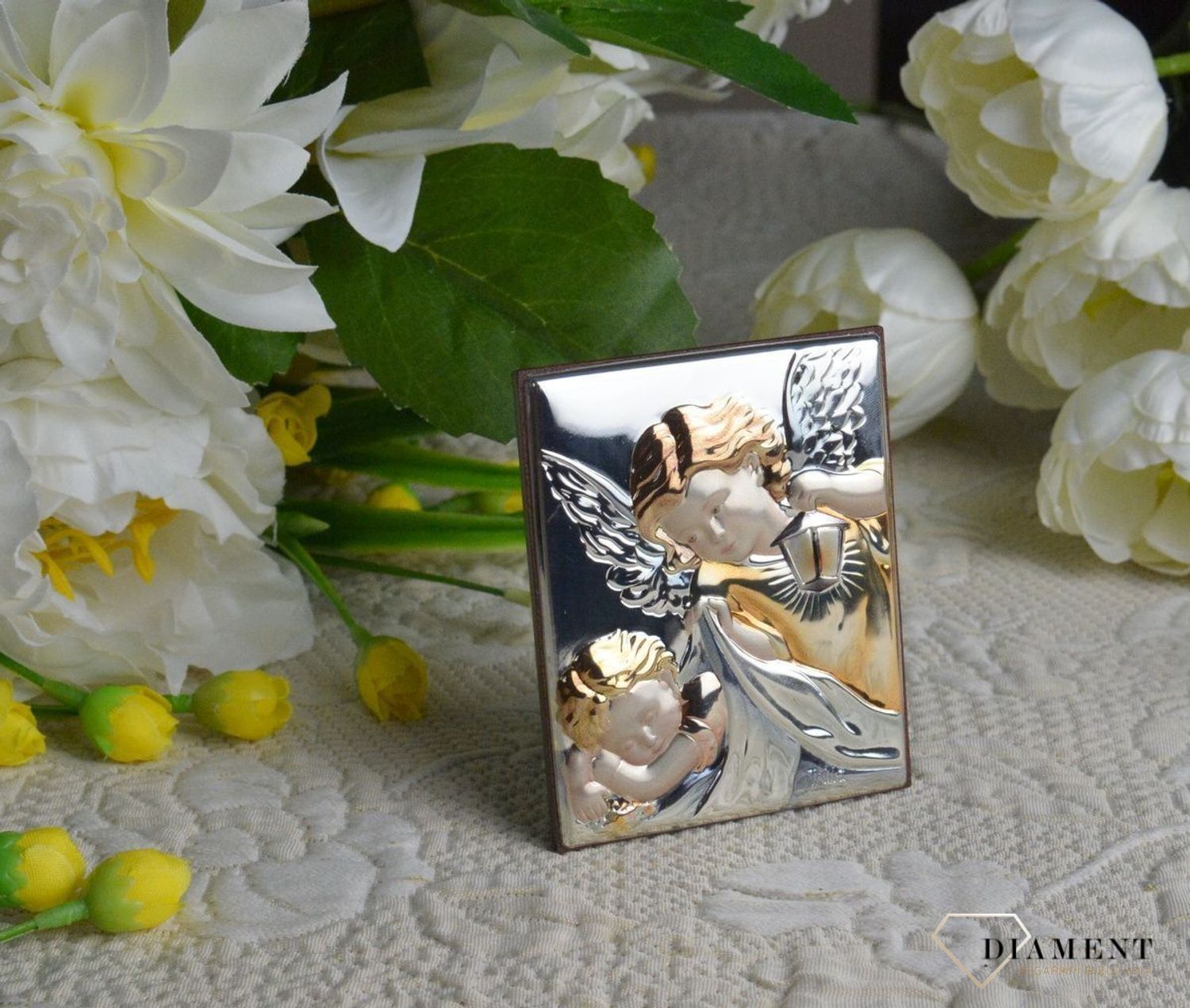 Obrazek srebrny z Aniołem Stróżem to piękna ozdoba dziecięcego pokoju. Pamiątka jest symbolicznym przedstawieniem opieki roztoczonej nad malcem przez Bożą.jpg