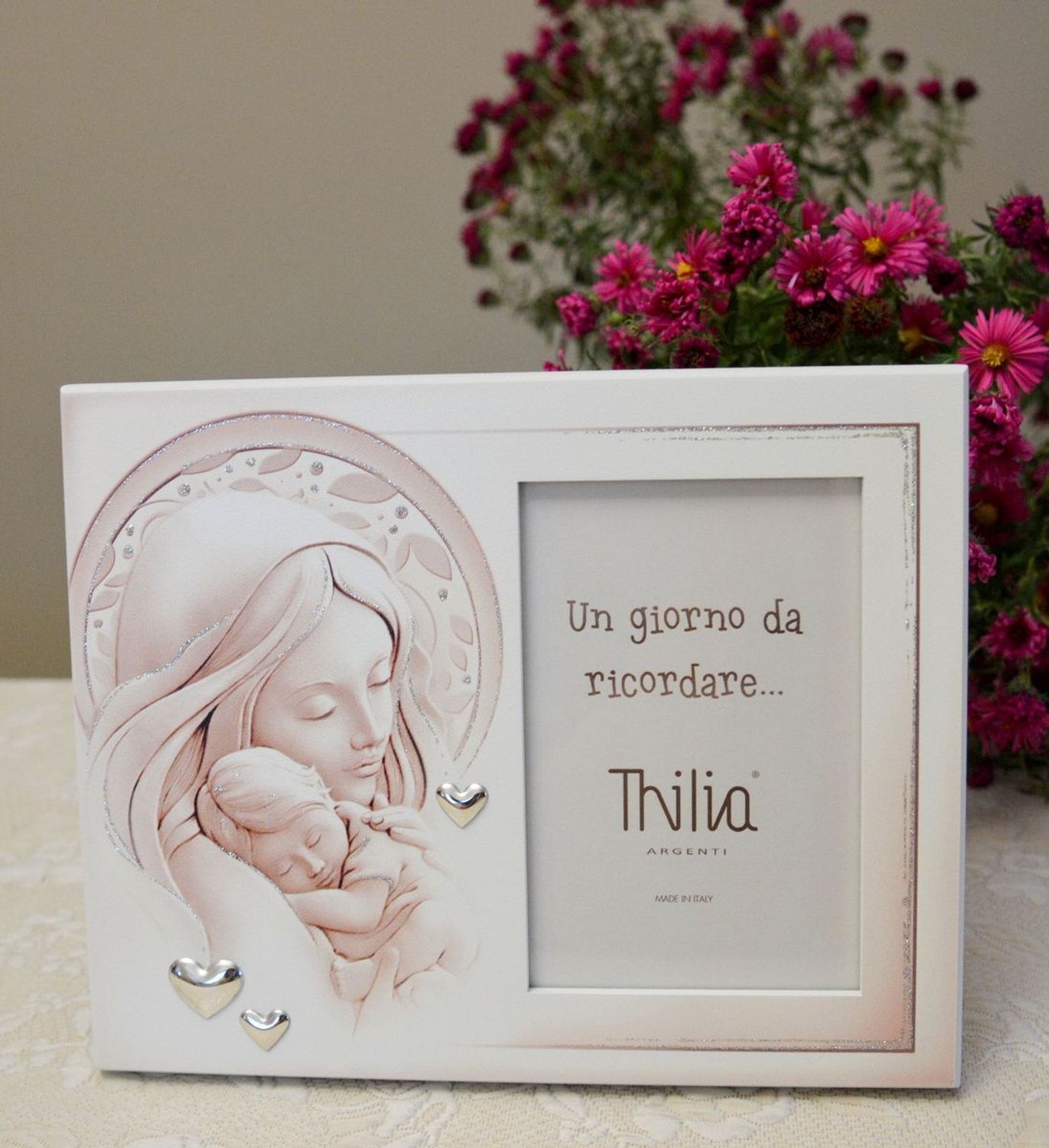 Wyjątkowa ramka na zdjęcie z wizerunkiem Matki Boskiej z Dzieciątkiem. Rozświetli każde wnętrze i sprawi, że zagości w nim atmosfera pełna miłości i ufności. Pięknie zdobiona posrebrzanymi sercami..webp