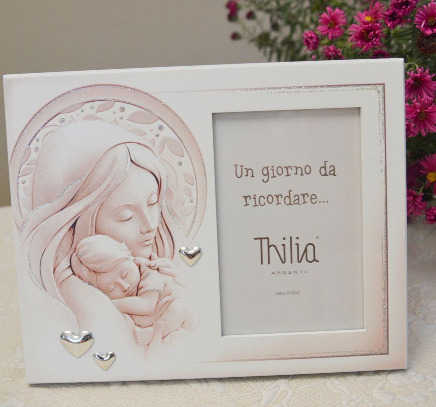 Wyjątkowa ramka na zdjęcie z wizerunkiem Matki Boskiej z Dzieciątkiem. Rozświetli każde wnętrze i sprawi, że zagości w nim atmosfera pełna miłości i ufności. Pięknie zdobiona posrebrzanymi sercami..webp