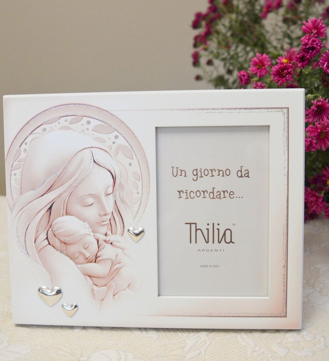 Wyjątkowa ramka na zdjęcie z wizerunkiem Matki Boskiej z Dzieciątkiem. Rozświetli każde wnętrze i sprawi, że zagości w nim atmosfera pełna miłości i ufności. Pięknie zdobiona posrebrzanymi sercami..webp