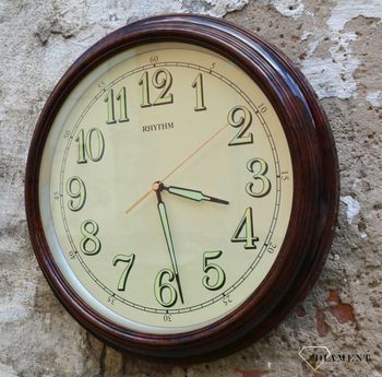 Zegar ścienny do salonu Rhythm CMG856NR06 to ozdobny, prosty zegar pasujący do każdego wnętrza. Ciekawa stylizacja zegara w kolorze brązowym. Wymarzony prezent (3).JPG