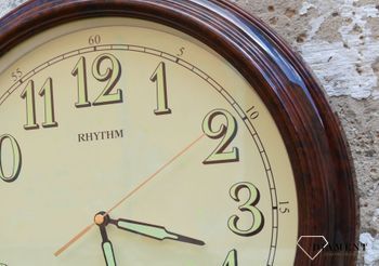 Zegar ścienny do salonu Rhythm CMG856NR06 to ozdobny, prosty zegar pasujący do każdego wnętrza. Ciekawa stylizacja zegara w kolorze brązowym. Wymarzony prezent (5).JPG