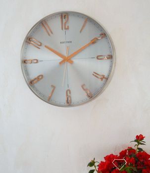Zegar ścienny do salonu srebrny Rhythm z różowym złotem CMG554NR19. Zegar ścienny do salonu zachowany w nowoczesnej formie. Okrągła obudowa wykonana z wysokiej jakości materiału metalu (1).JPG
