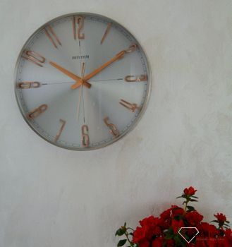 Zegar ścienny do salonu srebrny Rhythm z różowym złotem CMG554NR19. Zegar ścienny do salonu zachowany w nowoczesnej formie. Okrągła obudowa wykonana z wysokiej jakości materiału metalu (10).JPG