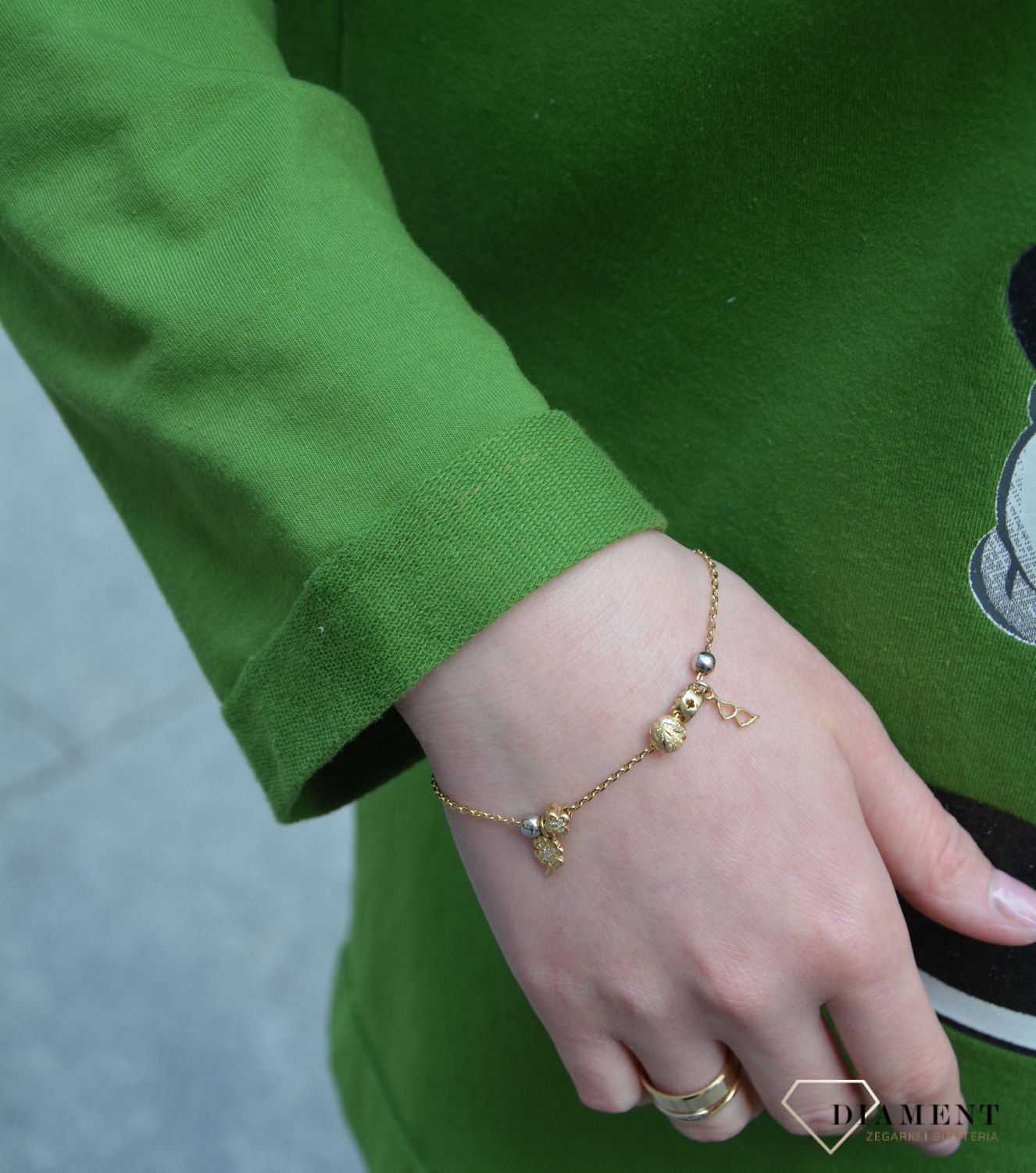 Złota bransoletka celebrytka z zawieszkami koniczynką i skrzydełkami. Złota bransoletka w kolorze żółtego złota wykonana z próby 585. Zapraszamy!  (1).jpg