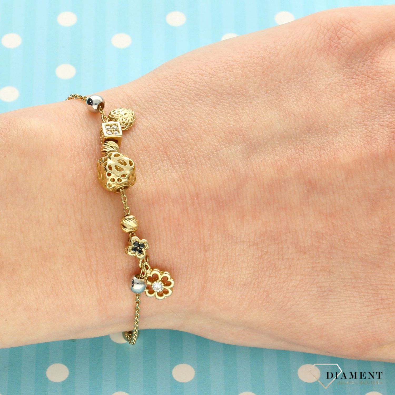 Złota bransoletka z ozdobnymi zawieszkami, które zostały ozdobione cyrkonią. Złota bransoletka idealna na prezent dla mam cx (1).jpg