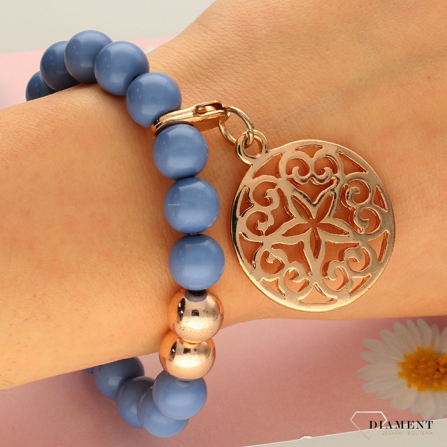 Bransoletka z niebieskich koralików z zawieszką w kolorze różowego złota DIA-BRA-0264-INNE. Piękny element pasujący do każdego rodzaju stylizacji (1).jpg