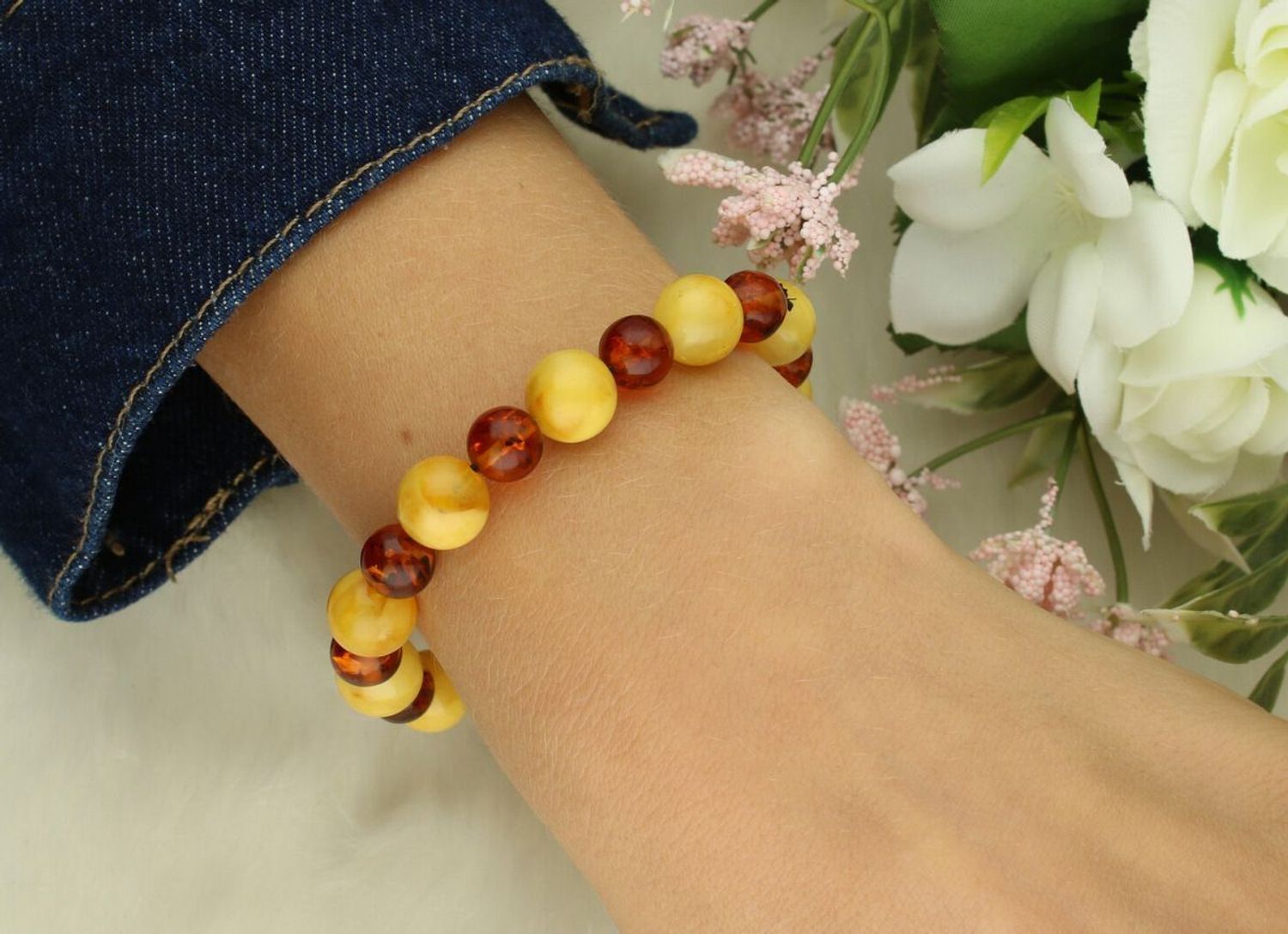 Bransoletka damska DIA-BRA-10533-INNE z okrągłymi bursztynami w odcieniach żółtego i brązu, wielkość kamieni 8–10 mm. Elastyczna gumka, obwód 16 cm. Elegancka biżuteria naturaln1.jpg