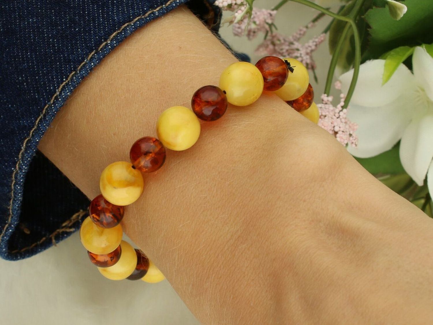 Bransoletka damska DIA-BRA-10533-INNE z okrągłymi bursztynami w odcieniach żółtego i brązu, wielkość kamieni 8–10 mm. Elastyczna gumka, obwód 16 cm. Elegancka biżuteria naturaln1.jpg